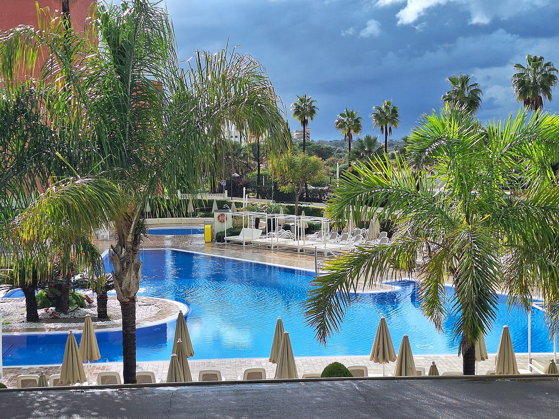 Hotel pool surrounded by palms in Cala Millor, Mallorca